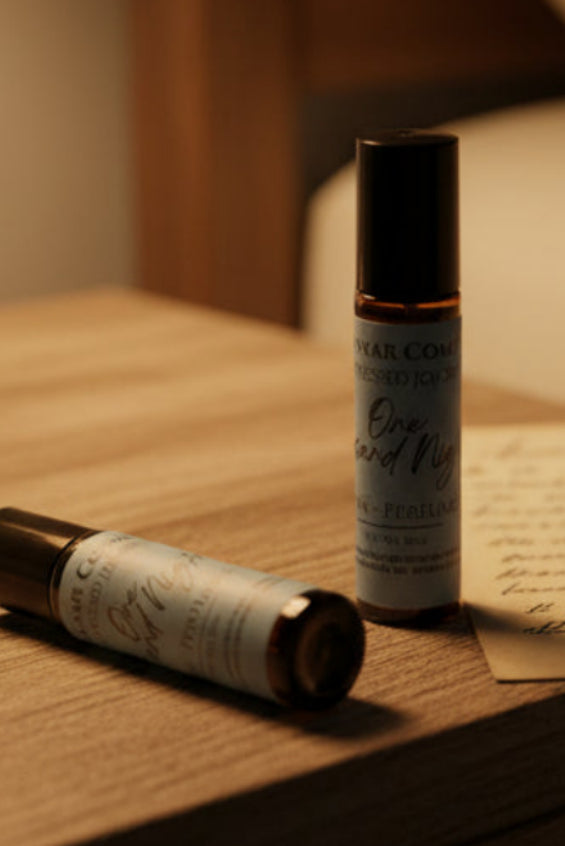 Two roller bottles of 'One and Night' perfume on a bathroom counter.