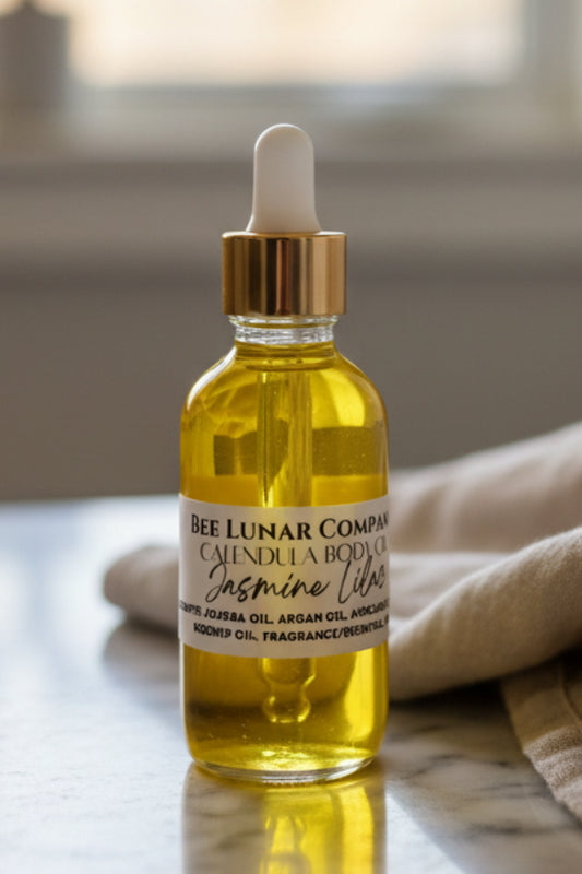 Bottle of Bee Lunar Company Calendula Body Oil on a wooden surface
