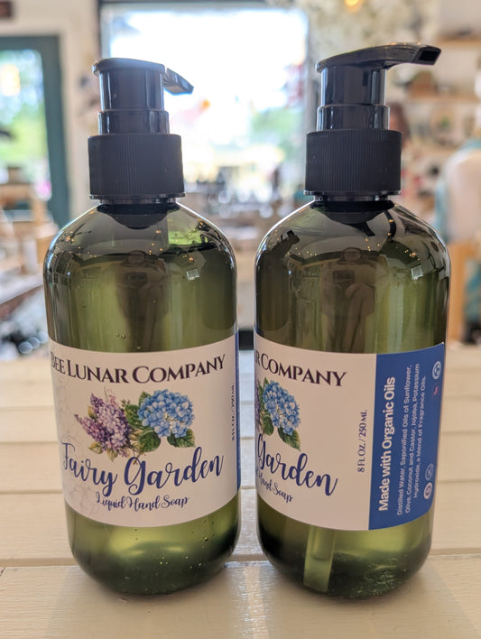 Two bottles of 'Fairy Garden' soap from the Tree Lunar Company on a wooden surface.