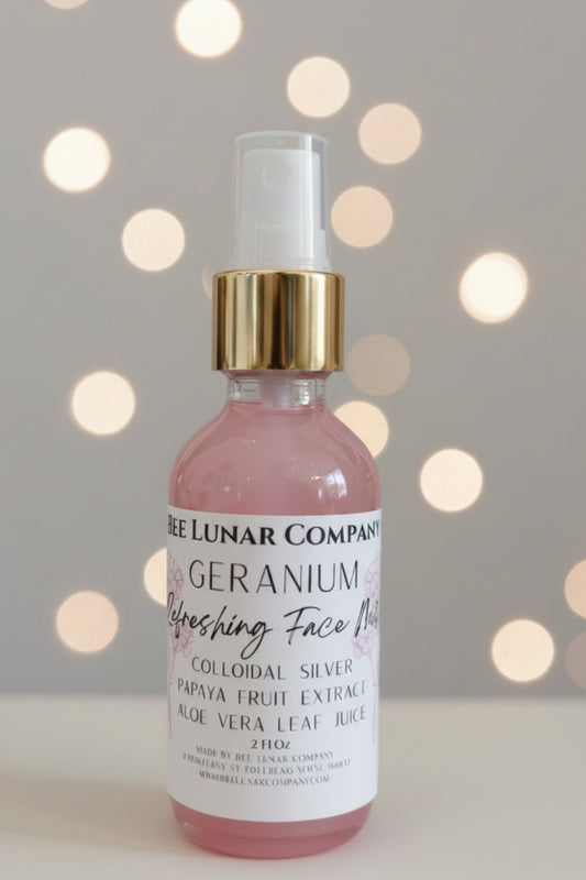 Bottle of 'Bee Lunar Company' Geranium Face Mist on white surface with a blurred background.